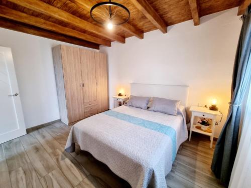 a bedroom with a bed and a wooden ceiling at Apartamento en Mala con vista al mar in Mala