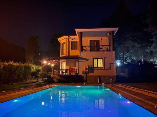 a house and a swimming pool in front of a house at night at Ihlamurlu Home in Sapanca