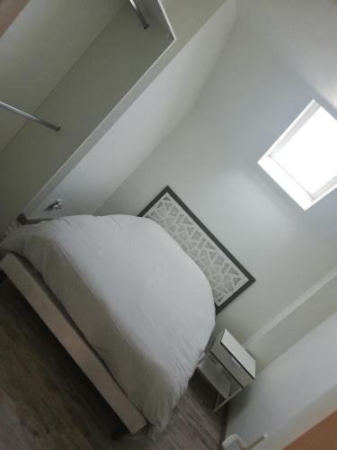 une chambre avec un lit et une lucarne dans l'établissement appartement neuf, à Villers-Outréaux