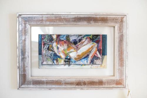 a painting in a wooden frame on a wall at Kea Ciel Villa in Ioulida