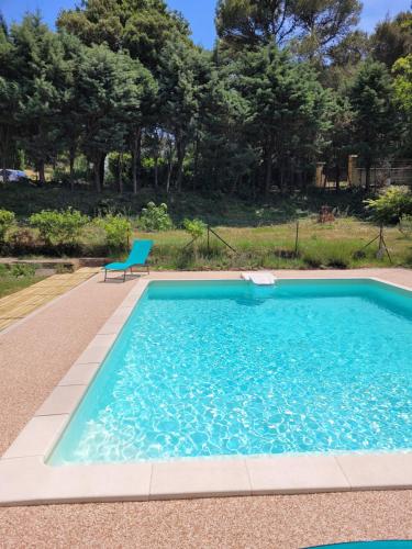 uma piscina com uma cadeira num quintal em Calourasso em Mondragon