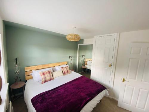 a bedroom with a large bed with a purple blanket at Coastal 2 bedroom maisonette with parking in Eastbourne