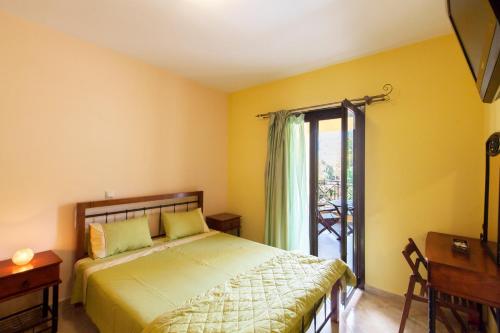 a bedroom with a bed and a sliding glass door at EXELLENT GUEST VILLA PRESTIGE in Asprogerakata
