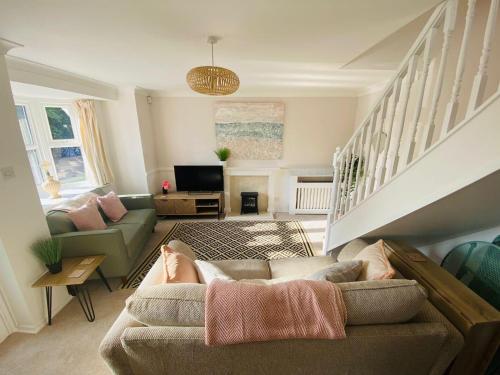 a living room with a couch and a tv at Coastal 2 bedroom maisonette with parking in Eastbourne