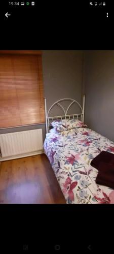 a bedroom with a bed with a floral bedspread at Mels accomodation in Letterkenny