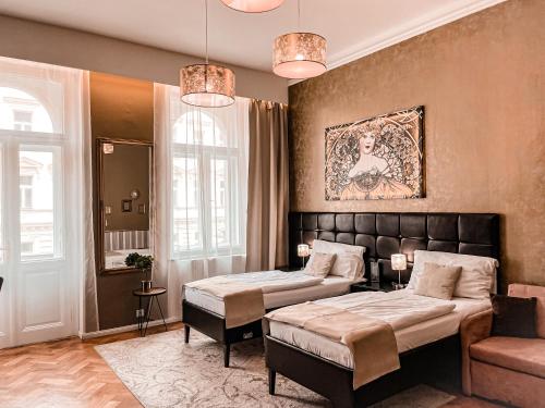 um quarto de hotel com duas camas e um sofá em Alfons Boutique Hotel em Praga