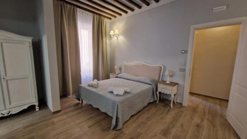 a bedroom with a bed and a table with towels on it at La Perla del Borgo B&B in Pisa