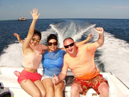 three people sitting on a boat in the water at Ras Rana Lodge in Rasdu