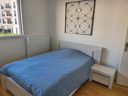 a bedroom with a blue bed and a window at Superbe Appartement à 3min à pieds de la gare in Chessy