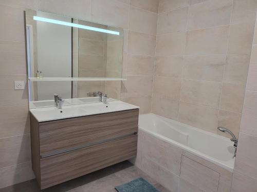 uma casa de banho com um lavatório e uma banheira em Superbe Appartement à 3min à pieds de la gare em Chessy