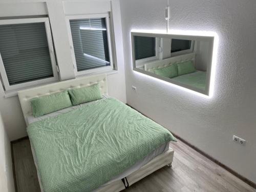 een kleine slaapkamer met een bed en 2 spiegels bij Apartments Rakovac in Živinice