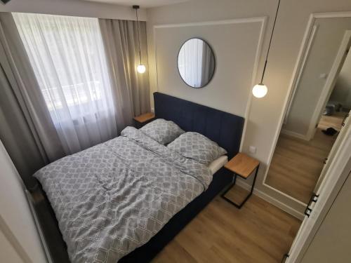 a small bedroom with a bed and a mirror at SEASIDE APART in Kołobrzeg