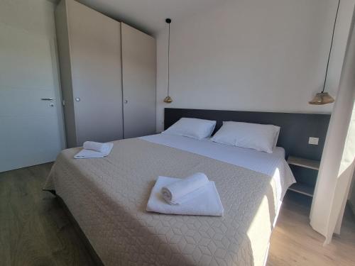 a bedroom with a bed with two towels on it at Villa Madison in Posedarje