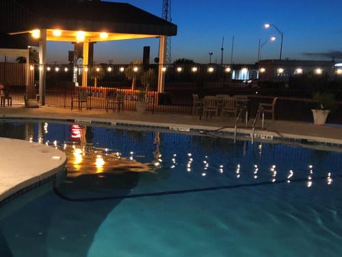 a swimming pool with a fountain and a chair in front of it at The Classic Desert Aire Hotel in Alamogordo