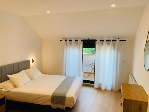a bedroom with a bed and a large window at Apartamentos Best Ainsa in Aínsa