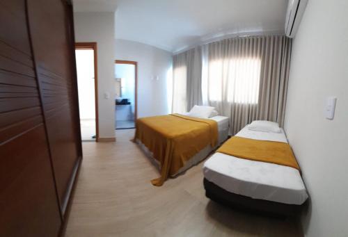 ein Hotelzimmer mit zwei Betten und einem Fenster in der Unterkunft Casa PraiAmar 20 in Prado