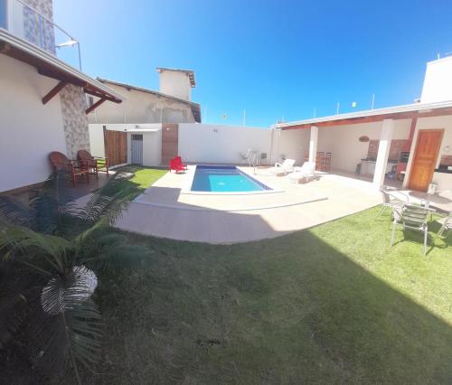 ein Hinterhof mit einem Swimmingpool und einem Haus in der Unterkunft Casa PraiAmar 20 in Prado