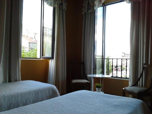 pokój hotelowy z dwoma łóżkami i oknem w obiekcie Hotel Luzon w mieście San Vicente de la Barquera