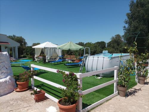einen Hinterhof mit einem Pool und einem Zaun mit Pflanzen in der Unterkunft Trullo Libellula in Ceglie Messapica