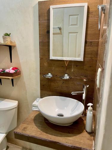 a bathroom with a white sink and a mirror at Estudios Rehilete in Holbox Island