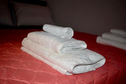una pila de toallas blancas sentadas en una cama en ΚΟΥΛΟΥΝΤΡΗ (1) en Symi