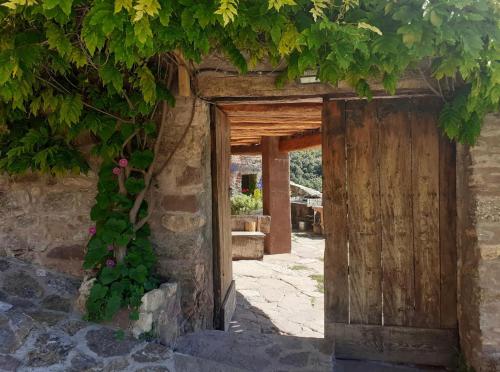 una entrada a un edificio de piedra con puerta de madera en Casa Manel - Loft rústico con encanto, en Montcortès