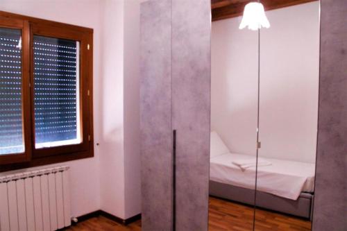 a small room with a bed and a glass wall at Venice Suites in Mestre