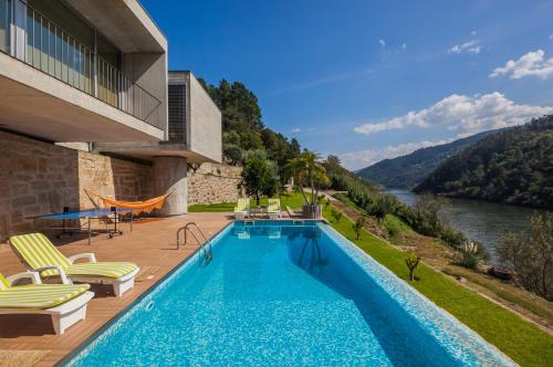 a swimming pool on a deck with a view of a river at Vila Spa Douro Piscina e acesso privado rio Douro in São Lourenço do Douro
