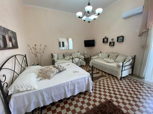 a bedroom with a bed and a living room with a couch at B&B CASA PUPETTA in Torre del Greco
