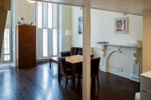 a living room with a dining room table and chairs at Marylebone Inn in London