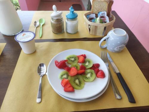 a plate of strawberries and kiwis on a table at Agriturismo Campolungo in Sant'Ermo