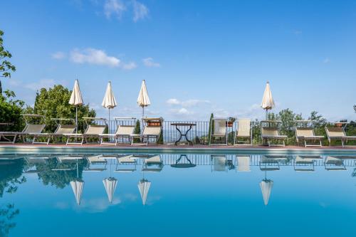 a pool at a hotel with chairs and umbrellas at Podere Mezzastrada - Place of Charme in Fiano
