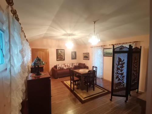 un soggiorno con tavolo e divano di Apartmani Vojinović a Sjenica