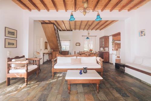 a living room with two beds and a table at Romano garden house - land tales in Agios Romanos