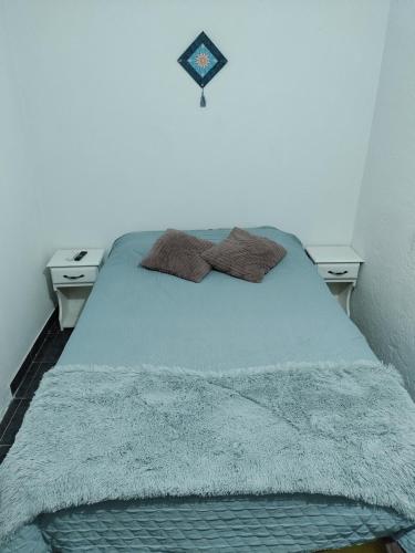 um quarto com uma cama com duas mesas de cabeceira em La Gloria em Merlo