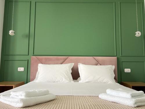 a bedroom with a bed with two towels on it at Ginger Home Tirana in Tirana