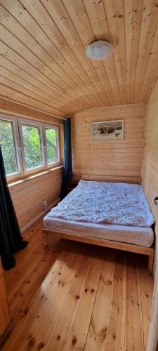 a bedroom with a bed in a wooden room at Święty spokój na pięterku in Stańkowa