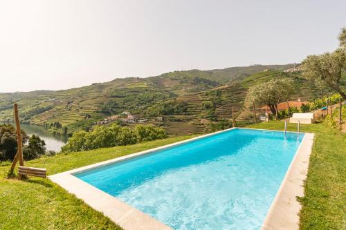 a blue swimming pool with a view of a mountain at DouroParadise in Peso da Régua