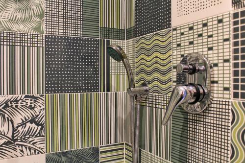 a shower in a bathroom with colorful tiles at Villa Ines in Maiori