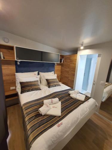 a large bed with two towels on top of it at Mobile home Linico in Biograd na Moru