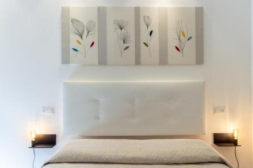 una camera con un letto bianco con due luci di Rooms Best Vacation Ever a Cagliari