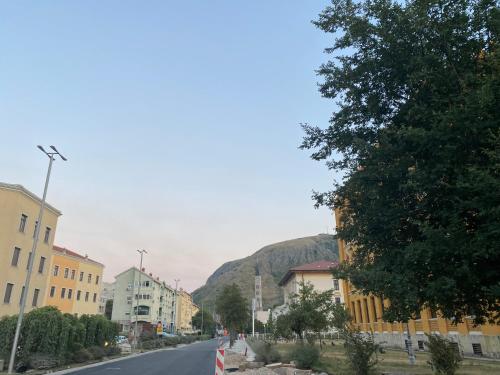 une rue dans une ville avec une montagne en arrière-plan dans l'établissement Capital apartments - CITY CENTRE, à Mostar