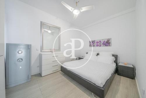 um quarto branco com uma cama com um grande sinal de PHP em Madrid Central, Apartamento Plaza de España em Madri