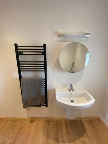 y baño con lavabo y espejo. en An Taigh Dubh- One bedroomed cottage, en Creagorry