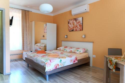 a small bedroom with a bed and a mirror at Apartments Nives in Cres