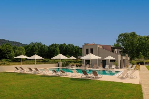 a swimming pool with lounge chairs and umbrellas at Marajo Suites in Skala Potamias