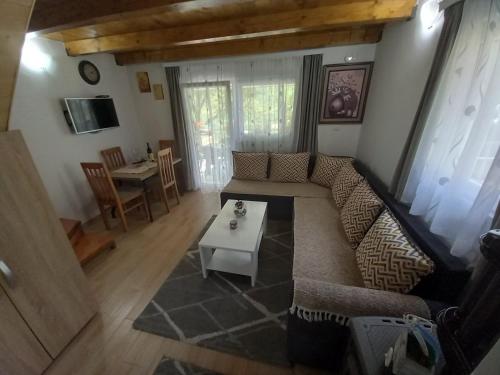uma sala de estar com um sofá e uma mesa em Apartman Stević em Pluzine