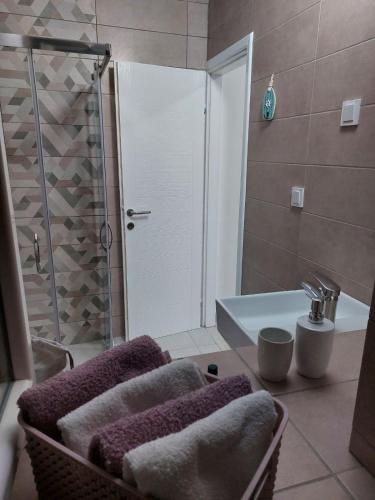 a bathroom with a shower and a sink with towels at Apartment Cattaro magico in Kotor