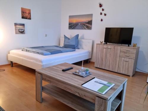 a living room with a bed and a coffee table at BRISE Business Apartment nahe Leipziger Messe - Porsche - BMW - DHL - WLAN - Parkplatz - business travelers only in Leipzig