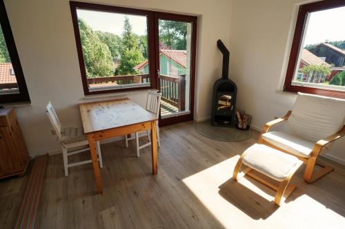 een woonkamer met een bureau, een stoel en een open haard bij Ferienwohnung mit Seeblick und Strand in Zislow